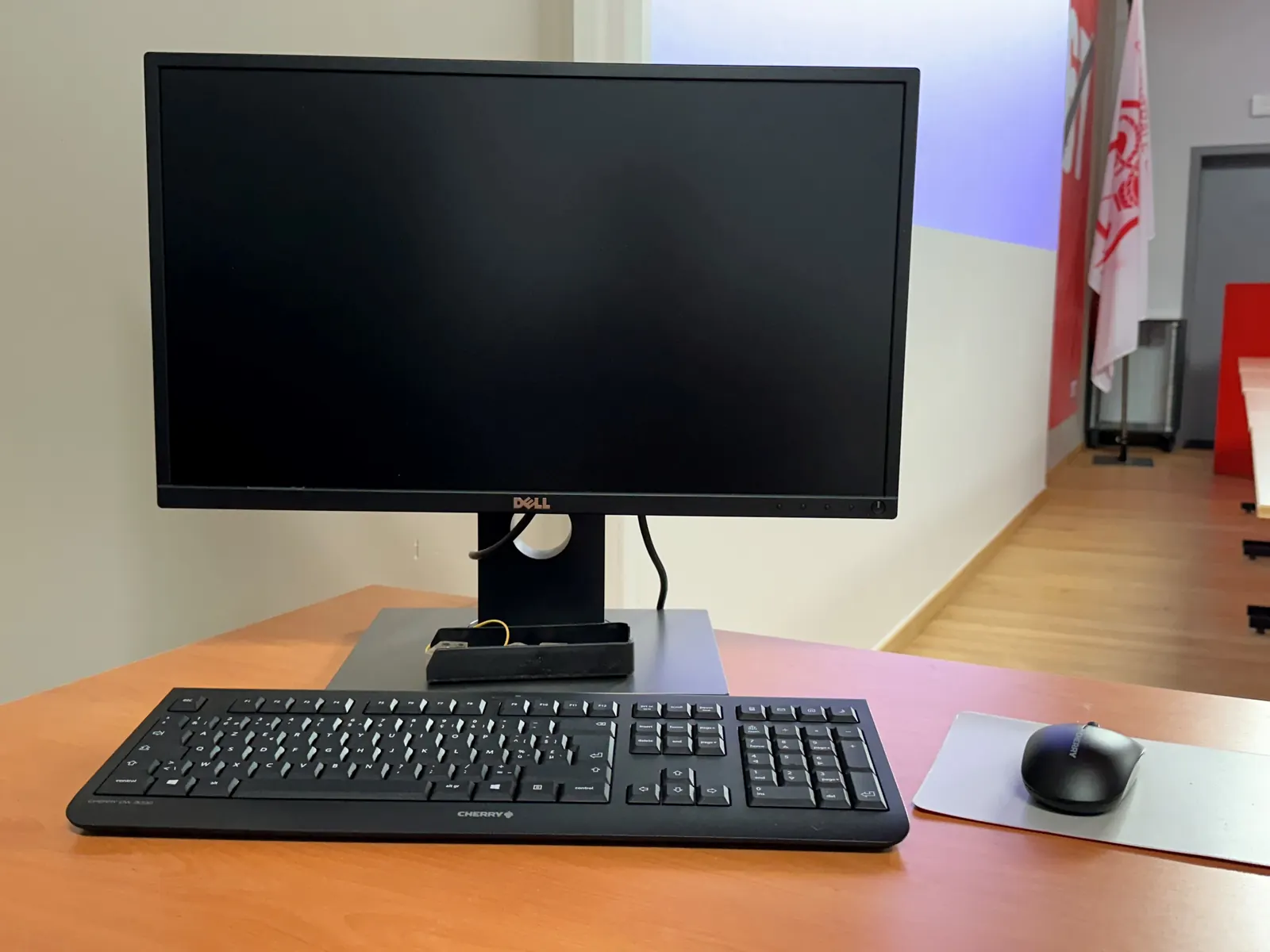 Ordinateur avec écran, clavier et souris à disposition sur une table.