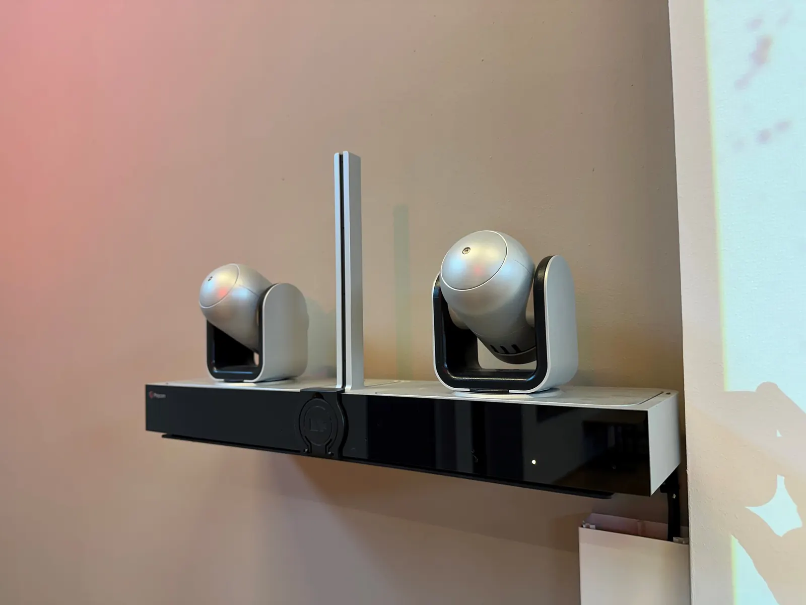 Barre de visioconférence avec deux caméras motorisées fixée au mur.